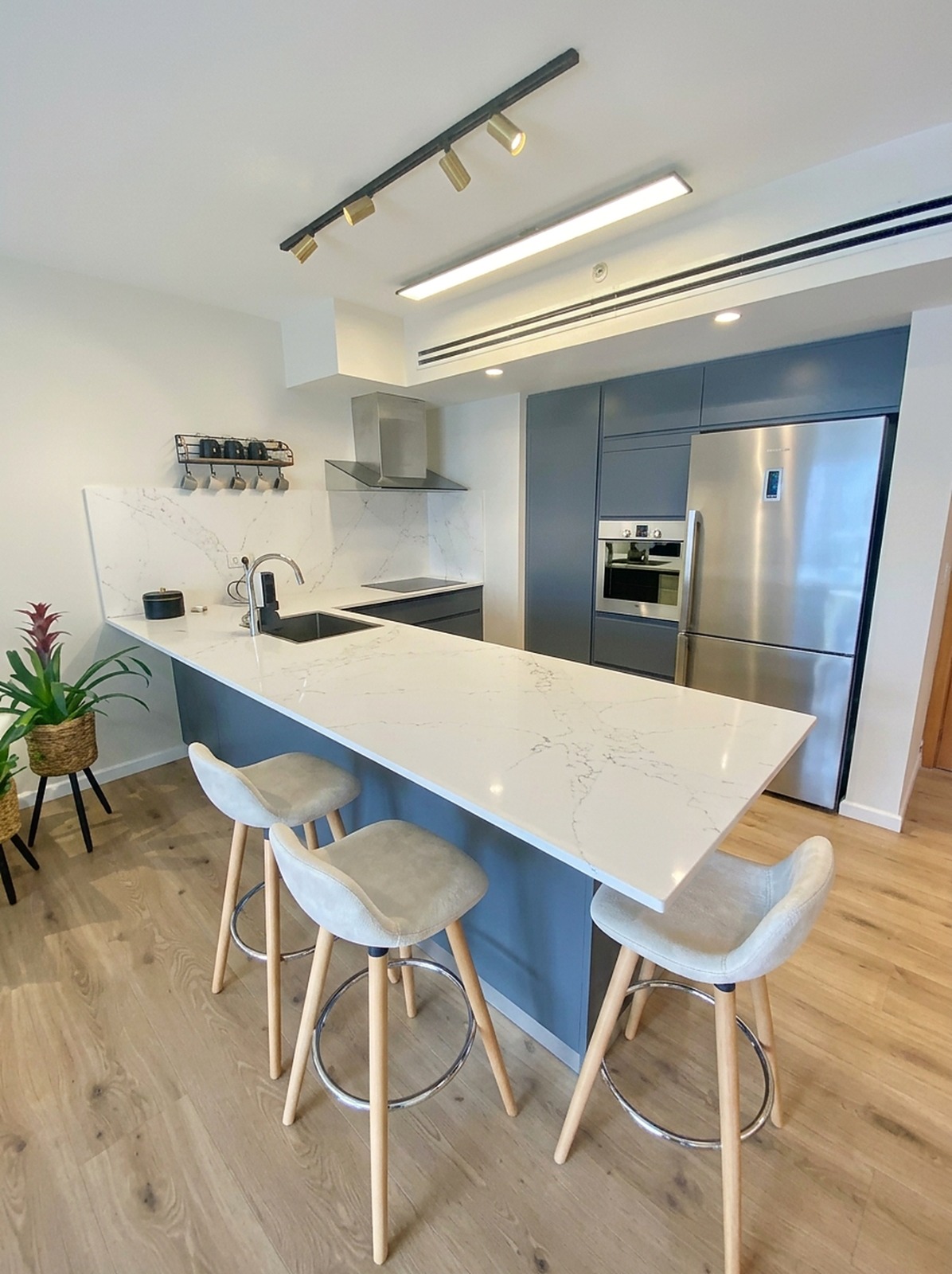 Modern upgraded kitchen with marble-effect worktop, bar seating and integrated appliances